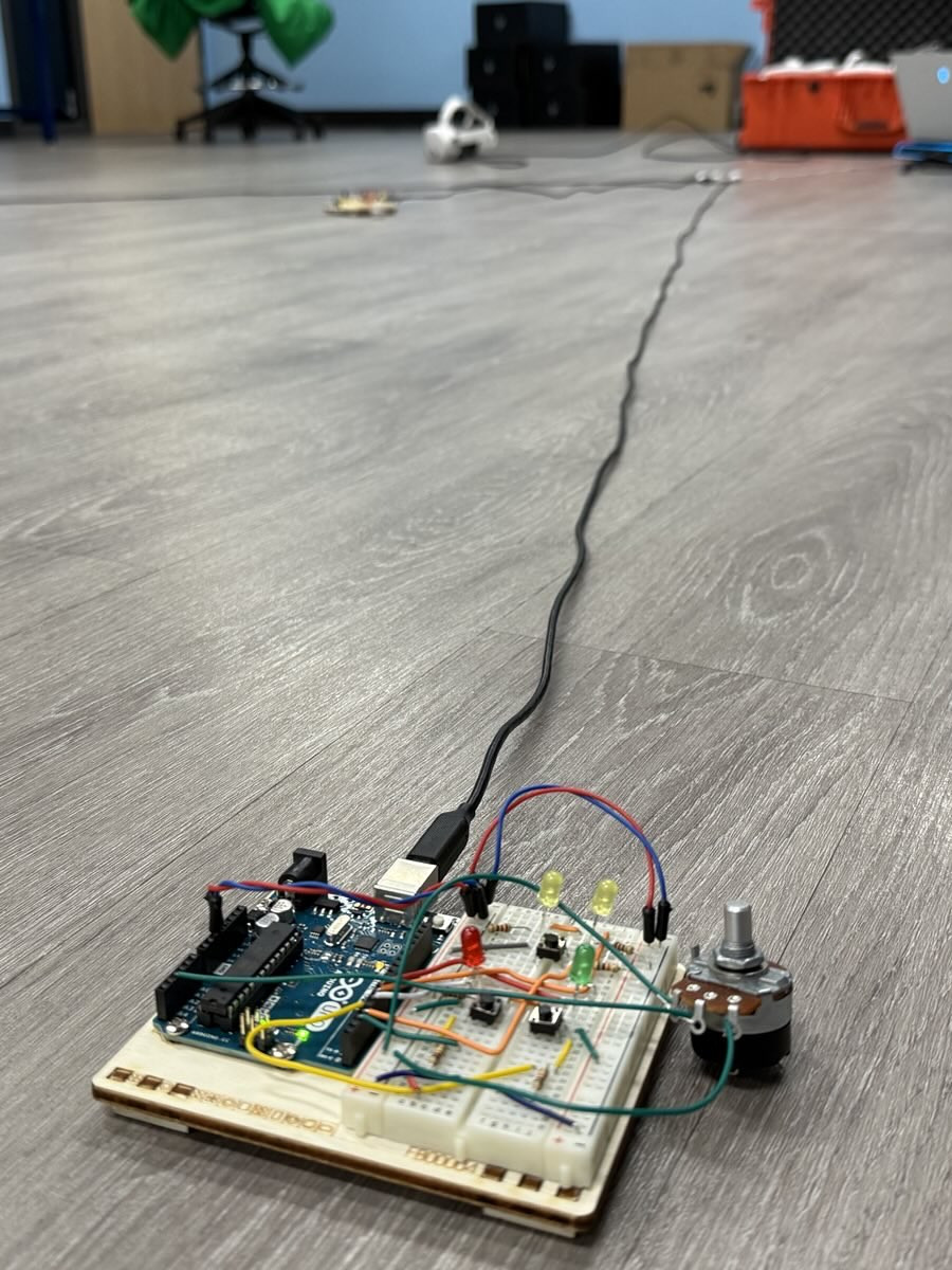 An image of a breadboard, Arduino, and various other components attached to a wiring harness.